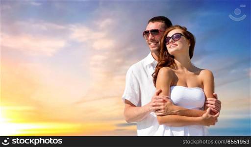 love, summer and relationships concept - happy smiling couple in sunglasses over evening sky background. happy smiling couple in sunglasses. happy smiling couple in sunglasses
