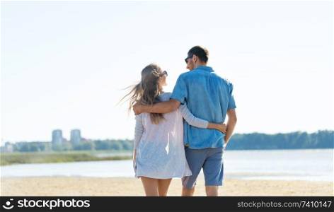 love, summer holidays and people concept - happy couple hugging on beach. happy couple hugging on summer beach