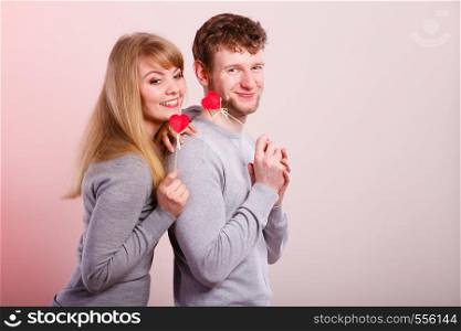 Love symbol romance relationship fun leisure concept. Girl with boy playing together. Youthful couple holding hearts smiling.. Girl with boy playing together.