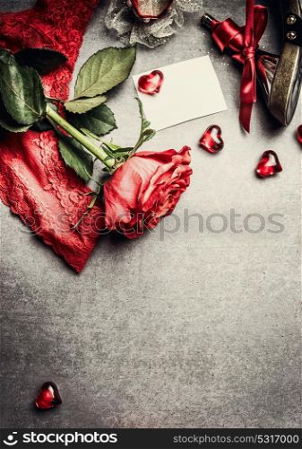 Love symbols and Valentines day greeting card with red roses and hearts on gray background, top view, place for text