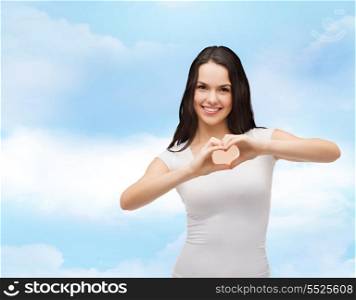 love, t-shirt design and happy people concept - smiling girl in white blank t-shirts showing heart with hands