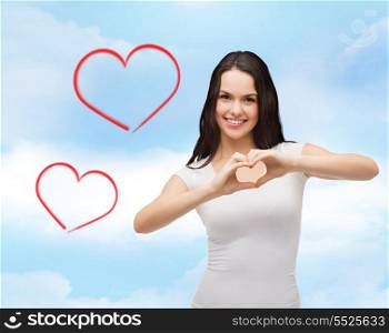 love, t-shirt design and happy people concept - smilinjg girl in white blank t-shirts showing heart with hands
