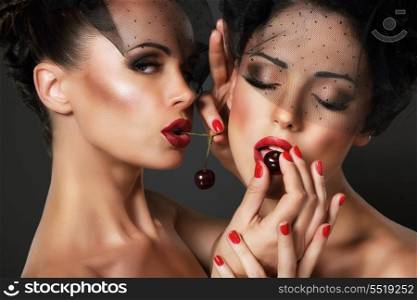 Love. Temptation. Pair of Sexy Women Eating Cherry Berries
