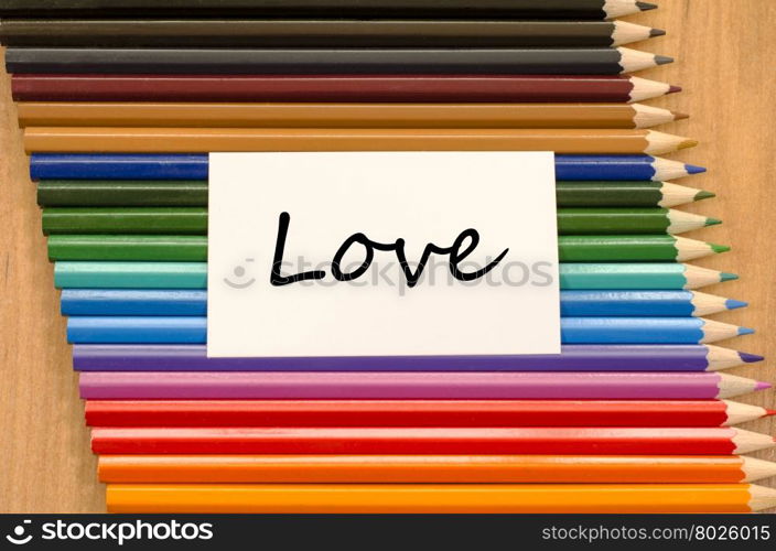 Love text concept and colored pencil on wooden background