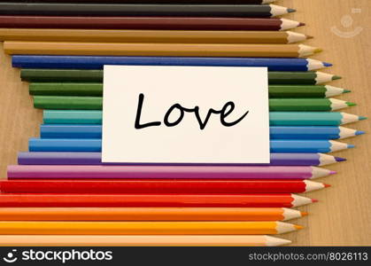 Love text concept and colored pencil on wooden background
