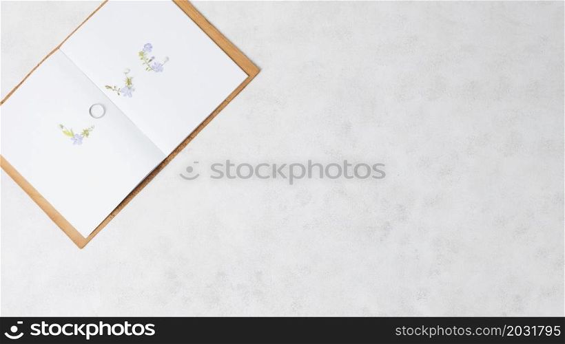 love text made with wedding ring open book concrete backdrop