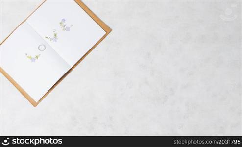 love text made with wedding ring open book concrete backdrop