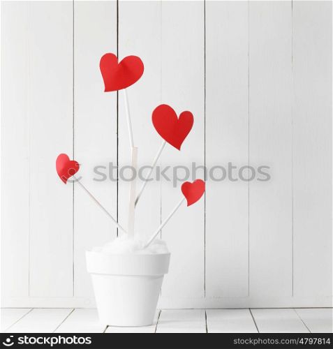 Love tree in flower pot. Love tree with red heart shaped leaves in white flower pot