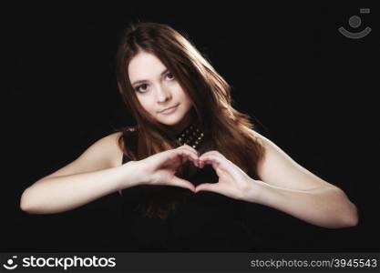 Love valentine&#39;s day concept. Woman teen girl doing forming heart shape love symbol with her hands on black