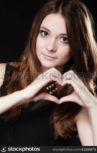 Love valentine&#39;s day concept. Woman teen girl doing forming heart shape love symbol with her hands on black