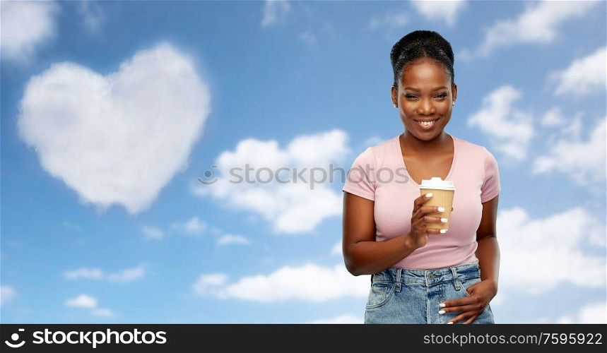 love, valentine&rsquo;s day and drinks concept - happy african american young woman drinking takeaway coffee from paper cup over grey background. happy african american woman drinking coffee