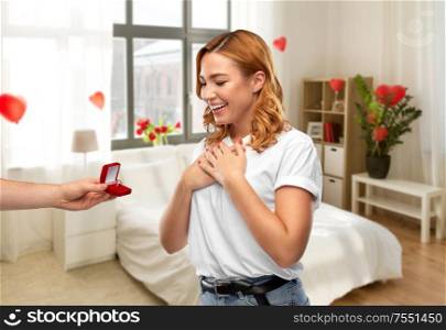 love, valentine&rsquo;s day and proposal concept - man giving diamond engagement ring in little red box to happy woman over home bedroom decorated with heart shaped balloons background. man giving woman engagement ring on valentines day