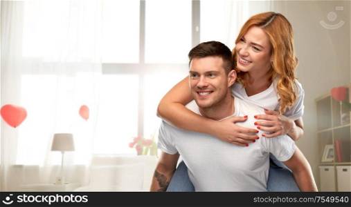 love, valentine&rsquo;s day and relationships concept - portrait of happy couple in white t-shirts having fun over home room decorated with heart shaped balloons background. happy couple in love having fun on valentines day