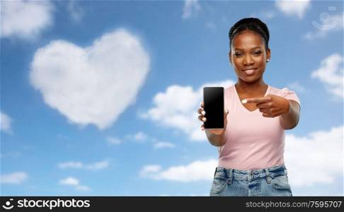 love, valentine&rsquo;s day and technology concept - happy african american woman using smartphone over grey background. happy african american woman using smartphone