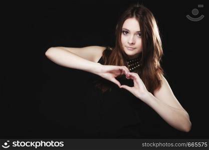 Love valentine's day concept. Woman teen girl doing forming heart shape love symbol with her hands on black