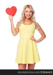 love, valentines day and people concept - smiling young woman in dress with red paper heart. happy young woman with red paper heart