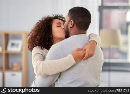 love, valentines day and relationships concept - happy african american couple kissing at home. happy african american couple kissing at home