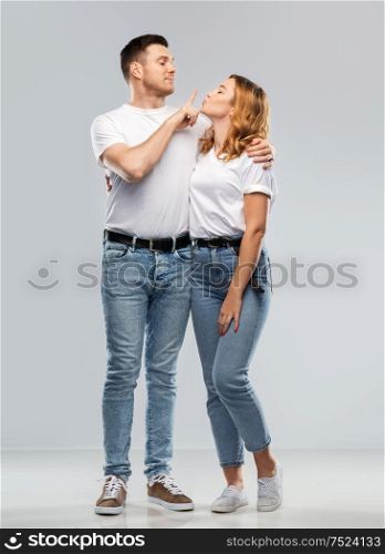 love, valentines day and relationships concept - portrait of happy couple in white t-shirts ready for kiss over grey background. couple in white t-shirts ready for kiss