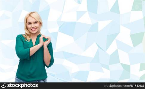 love, valentines day, gesture, plus size and people concept - smiling young woman in shirt and jeans showing heart shape hand sign over blue background