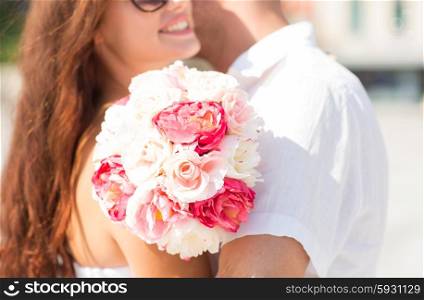 love, wedding, summer, dating and people concept - close up of couple with bunch of flowers hugging in city
