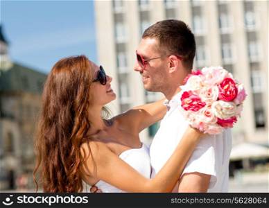 love, wedding, summer, dating and people concept - smiling couple wearing sunglasses with bunch of flowers hugging in city