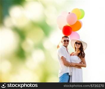 love, wedding, summer, dating and people concept - smiling couple wearing sunglasses with balloons hugging over green background
