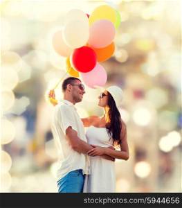 love, wedding, summer, dating and people concept - smiling couple wearing sunglasses with balloons hugging over lights background