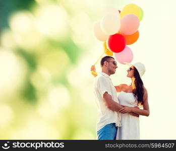 love, wedding, summer, dating and people concept - smiling couple wearing sunglasses with balloons hugging over green background