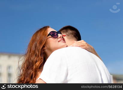 love, wedding, summer, dating and people concept - smiling couple wearing sunglasses hugging in city