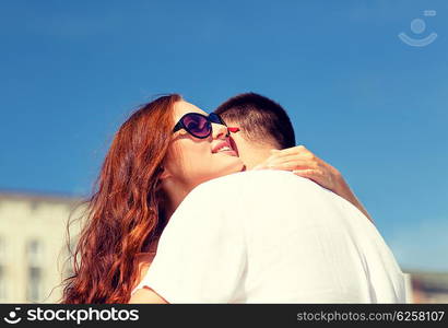 love, wedding, summer, dating and people concept - smiling couple wearing sunglasses hugging in city