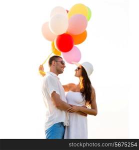 love, wedding, summer, dating and people concept - smiling couple wearing sunglasses with balloons hugging outdoors