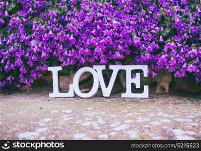 Love word in a purple floral garden