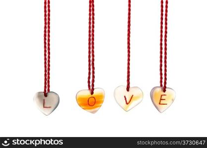 Love word spelled with agates that are engraved with white letters and are hung by ropes, isolated against white background