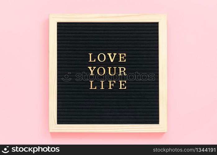 Love your life. Motivational quote in gold letters on black letter board on pink background, central composition . Top view Flat lay Copy space Concept inspirational quote of the day.. Love your life. Motivational quote in gold letters on black letter board on pink background, central composition . Top view Flat lay Copy space Concept inspirational quote of the day