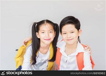 Lovely Asian couple school kids, 7 and 10 years old, over gray background