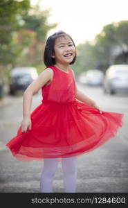 lovely asian girl wearing red skirt dress moving with happiness face outdoor