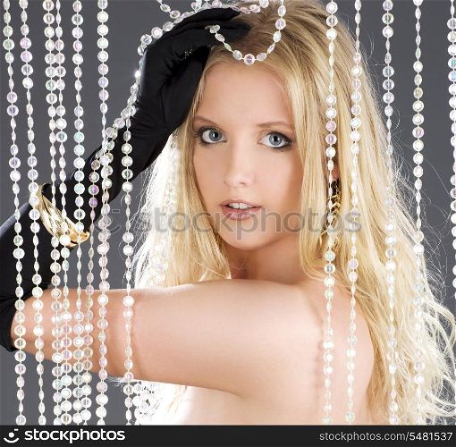 lovely blonde playing with crystal curtain over grey