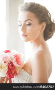 lovely bride with bouquet of flowers indoors.