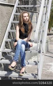 Lovely brunette girl sitting on the stairs