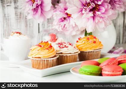 Lovely cakes and macaroons with coffee and flowers