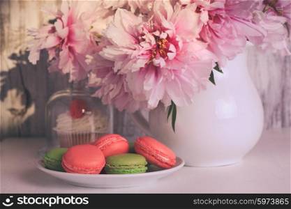 Lovely cakes and macaroons with coffee and flowers. Dessert and flowers
