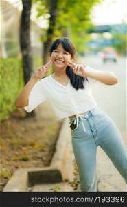 lovely face of asian teenager wearing easy casual clothes standing beside city street