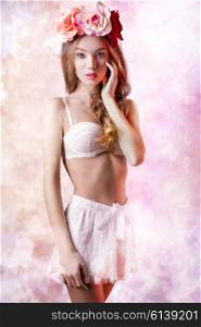 lovely female with spring flowers on the head and vintage lingerie posing with romantic expression, natural make-up and long wavy hair