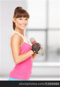 lovely fitness instructor with dumbbells in gym