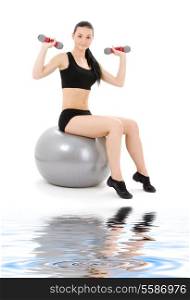 lovely fitness instructor with dumbbells on pilates ball