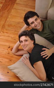 lovely friendship between sister and brother lying and relaxing on the floor next to couch