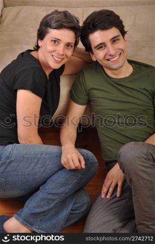 lovely friendship between sister and brother lying and relaxing on the floor next to couch