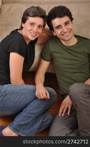 lovely friendship between sister and brother lying and relaxing on the floor next to couch