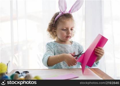 lovely girl cutting easter decorations