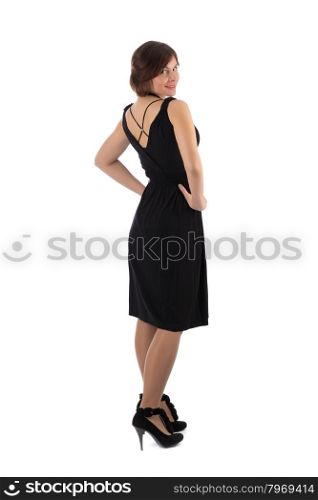 Lovely girl looks out from behind his back in the studio in a black dress. Isolate on white.